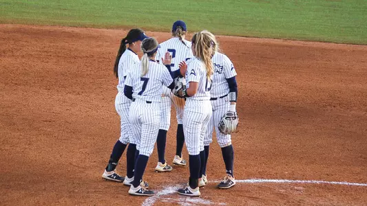 Softball huddles in the infield before a game at Troy.