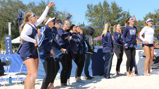 UNF beach volleyball celebrates together.