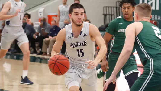 Jose Placer drives the basketball past a pair of defenders