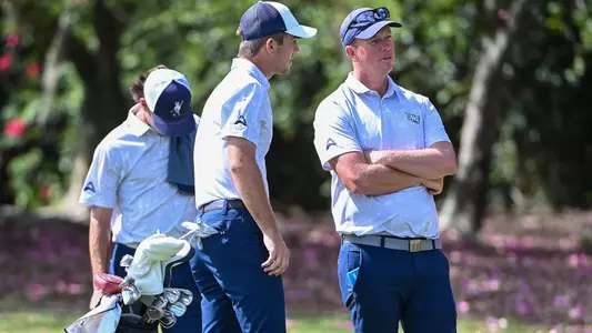 Coach Scott Schroeder chats with Robbie Higgins next to the green