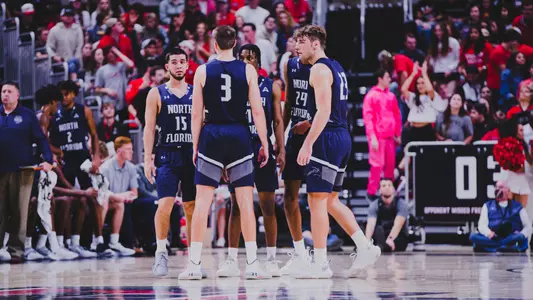 Men's basketball team huddles on the floor at Texas Tech