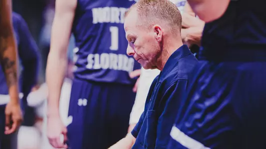 Matthew Driscoll sits in middle of huddle and draws up a play