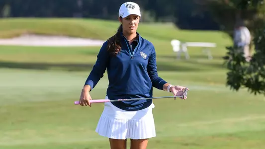 Mindy Herrick holds her putter while lining up a putt on the green