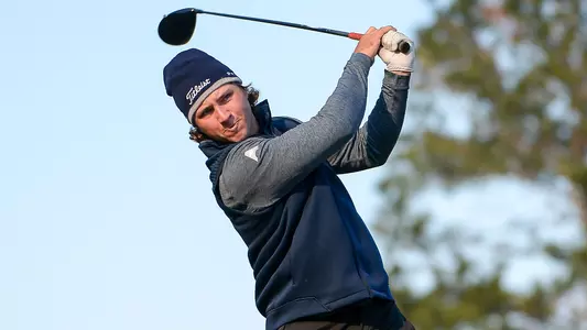 Grant Sutliff watches golf ball after swinging the club