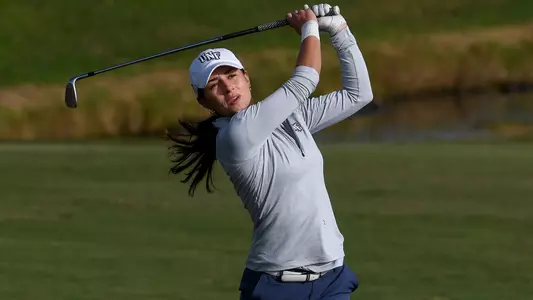 Marion Debove watches her ball on the follow through of her golf swing
