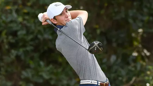 Nick Gabrelcik swings a golf club and watches flight of the ball