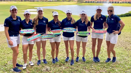 Women's golf team poses with the championship trophy of the Spring Break Shootout