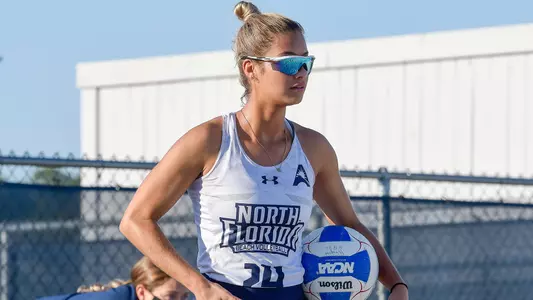 Marisa Rogers holds the beach volleyball.