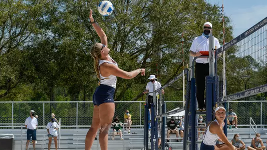 Lauren Galinis and Carleigh Semeniuk vs. JU during a beach volleyball point.