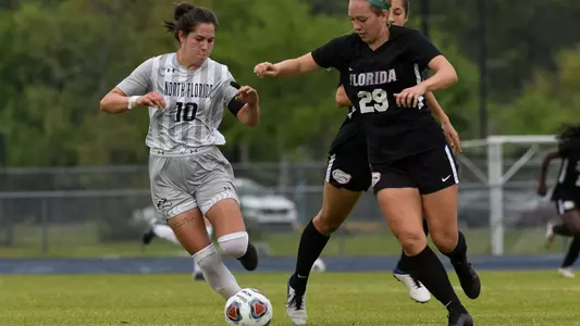 Thais Reiss dribbles a soccer ball past a Florida defender