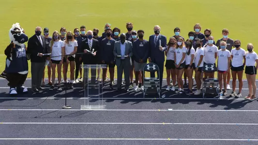 UNF Track & Field team poses with dignitaries on the track infield during press conference for renaming of facility to Visit Jax Track