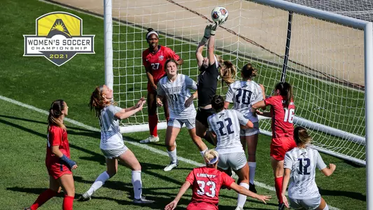 Osprey players surround the Liberty keeper as she punches the ball over the crossbar in the ASUN semifinal match