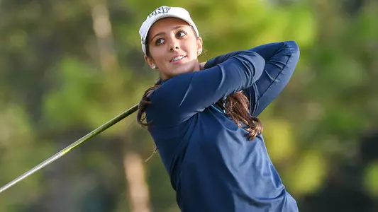 Mindy Herrick watches the flight of her ball following a swing of the golf club