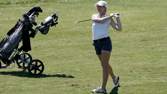 Christin Eisenbeiss stands next to her golf bag after taking a swing in the fairway