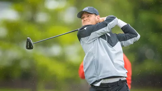 Nick Infanti swings his driver with a light rain falling