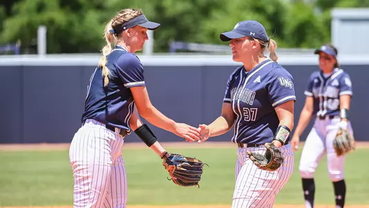 Morgan Clausen and Paige Pfent have a handshake at the softball field.