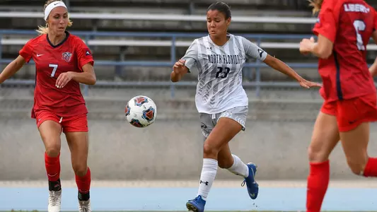 Devyn Encalada dribbles between a pair of defenders