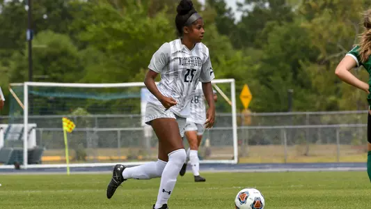 Morgan Robertson dribbles soccer ball past a defender
