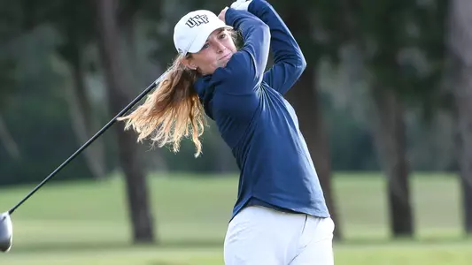 Kaitlynn Washburn swings the golf club on the tee box