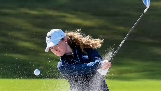 Kaitlynn Washburn hits a shot out of the sand trap