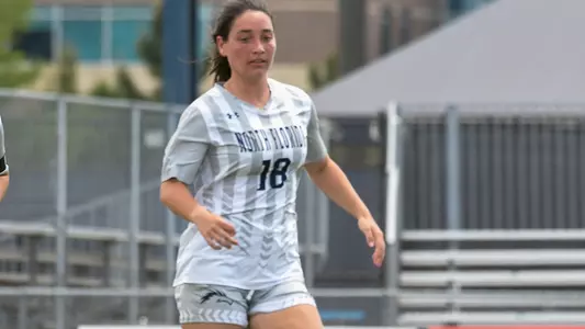 Kayla Bond dribbles the soccer ball on the field