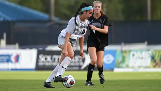 Ariana Munzo dribbling the soccer ball.