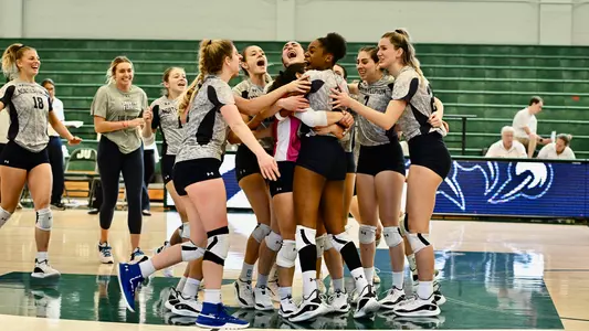 UNF volleyball team photo celebrating