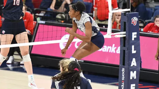 Mahalia White swinging at a ball by the net