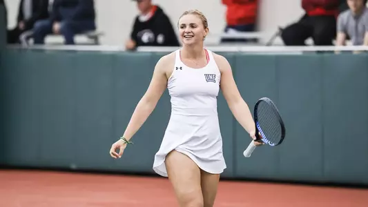 UNF Women's Tennis action shot with Summer Yardley smiling on the court