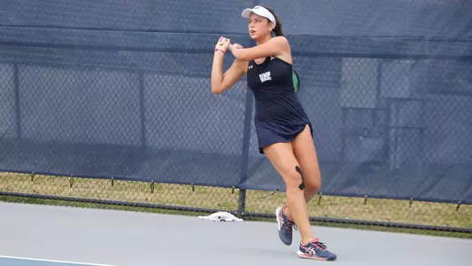 Isabel Oliveira hitting a backhand