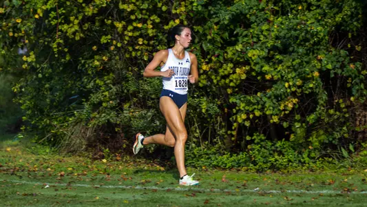 Mia McLain running on the grass in the 5k