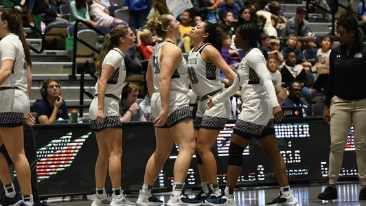 Women's basketball celebrating into the timeout