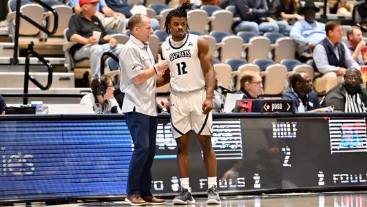 Jaylen Smith and Coach Driscoll on the sideline at basketball game
