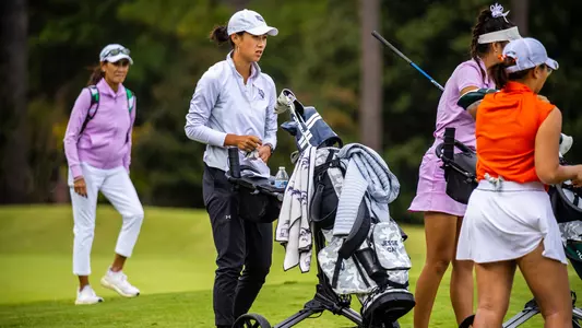 Jessie Cai guiding golf bag on cart