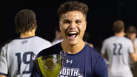 Michael Carrero holding JU game trophy