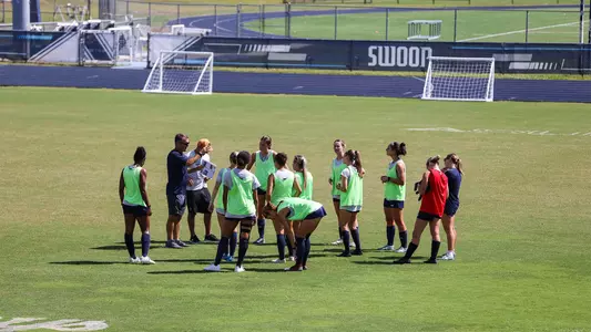 Coach Eric Faulconer talking to women's soccer during practice at Hodges Stadium