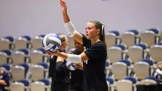 Maymie Guthrie going for a serve