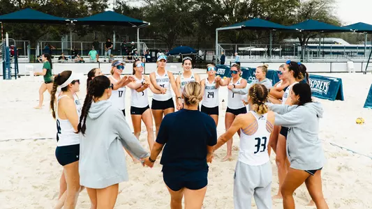 Beach volleyball huddling up at the Cooper Beach Volleyball Complex