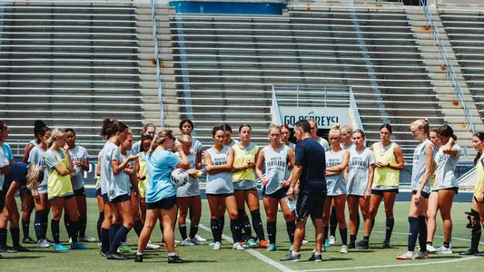 Women's Soccer coaches speaking with the team at Hodges Stadium