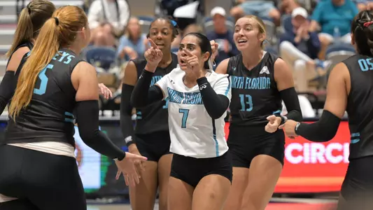 UNF volleyball team photo celebrating