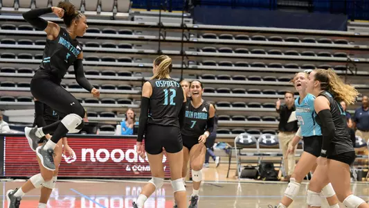 UNF volleyball team photo celebrating at UNF