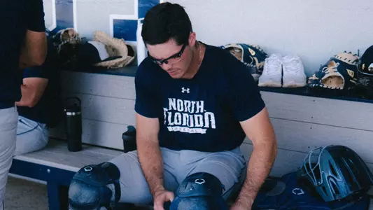 Catcher putting on equipment