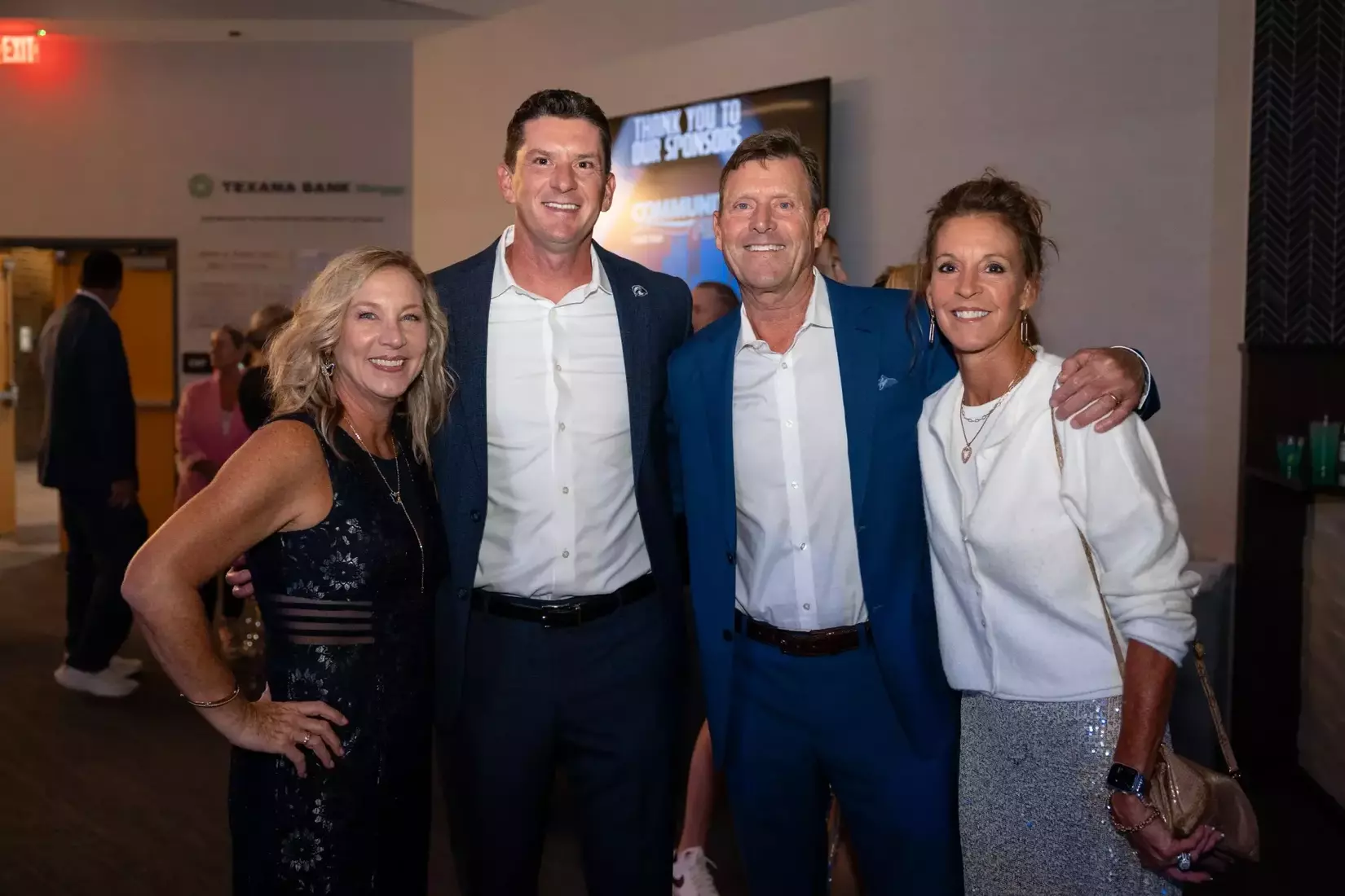 Four people gathered together for a posed photo