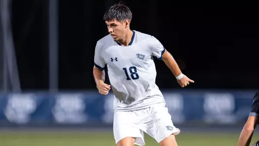 Omar Trto looks down at ball with approaching defender