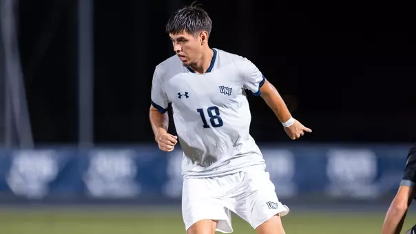Omar Trto looks down at ball with approaching defender