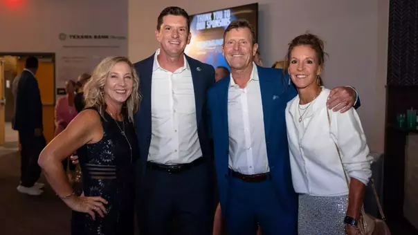 Four people gathered together for a posed photo