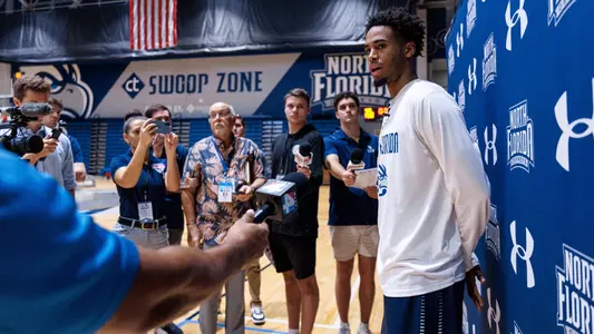 Elijah Elliott interviewed in front of a backdrop by media
