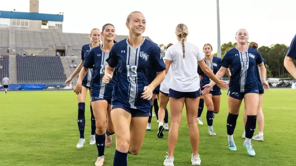 UNF Women's soccer team runs out to the field before the game.