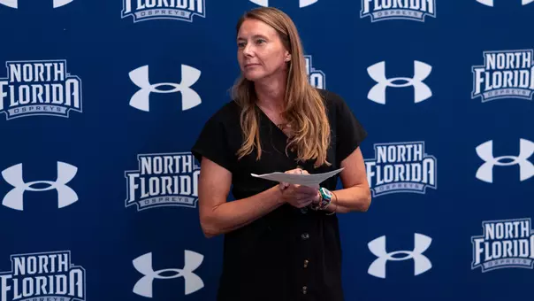Assistant AD for Student-Athlete Center for Excellence Tara Sunquist holding a list of graduates at summer graduation ceremony