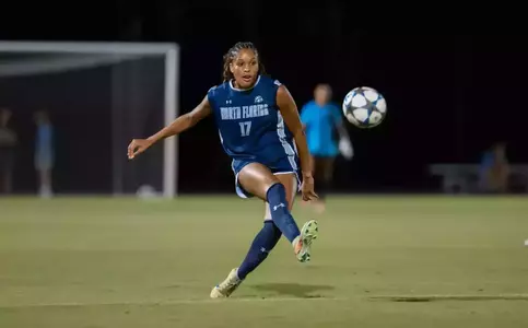 UNF Women's soccer player kicks a ball in the air.